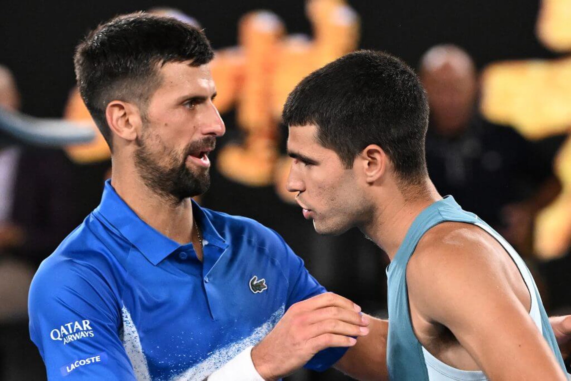 Serbia's Novak Djokovic (L) embraces Spain's Carlos Alcaraz after their men's singles quarterfinal match on day ten of the Australian Open tennis tournament in Melbourne on January 22, 2025. (Photo by WILLIAM WEST / AFP) / -- IMAGE RESTRICTED TO EDITORIAL USE - STRICTLY NO COMMERCIAL USE -- (Photo by WILLIAM WEST/AFP via Getty Images)