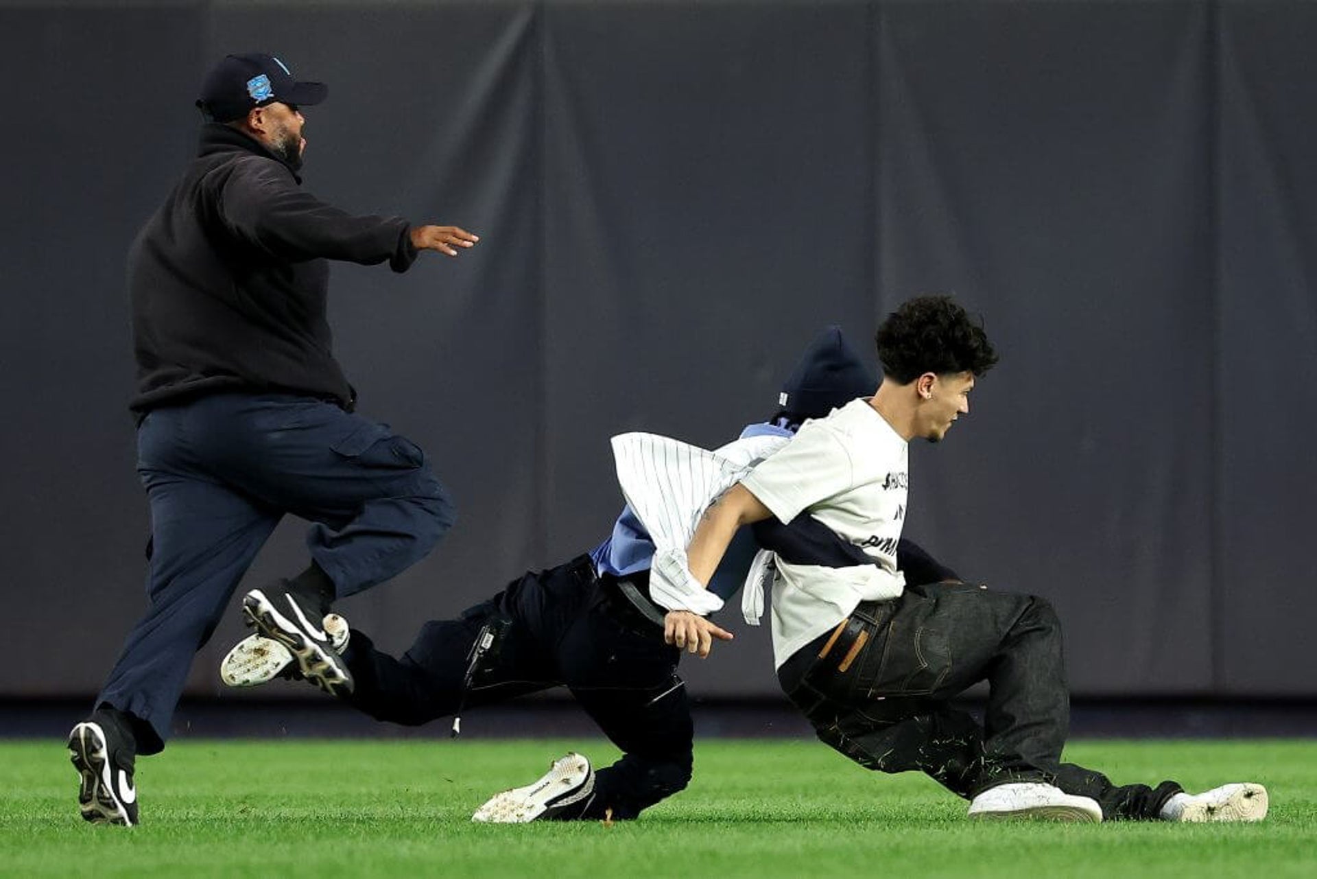 Yankee Stadium security members take down a fan who ran onto the field during Game 3 of the ALDS.