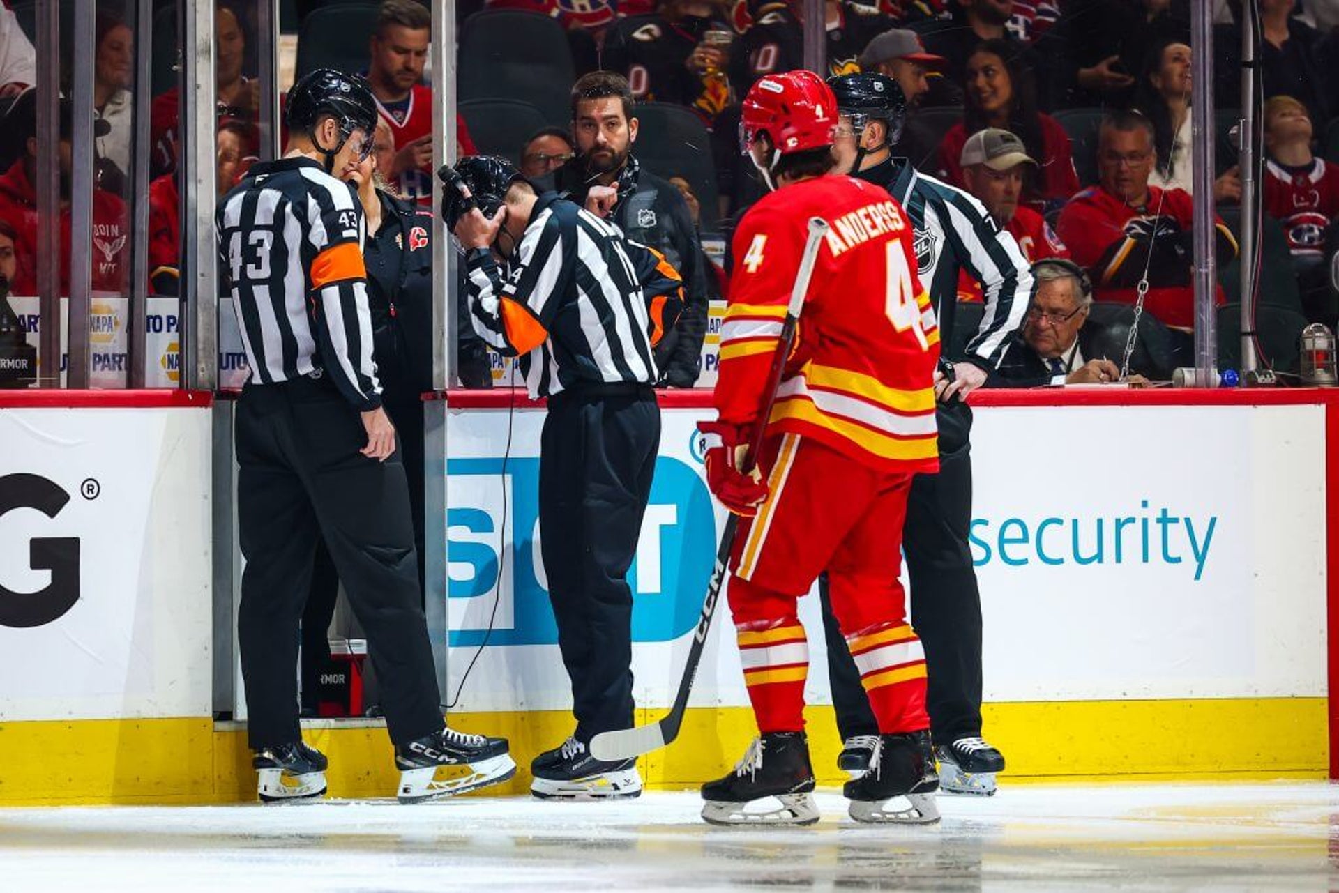 Flames defenseman Rasmus Andersson talks to referees about the lighting issue before the game against the Canadiens.