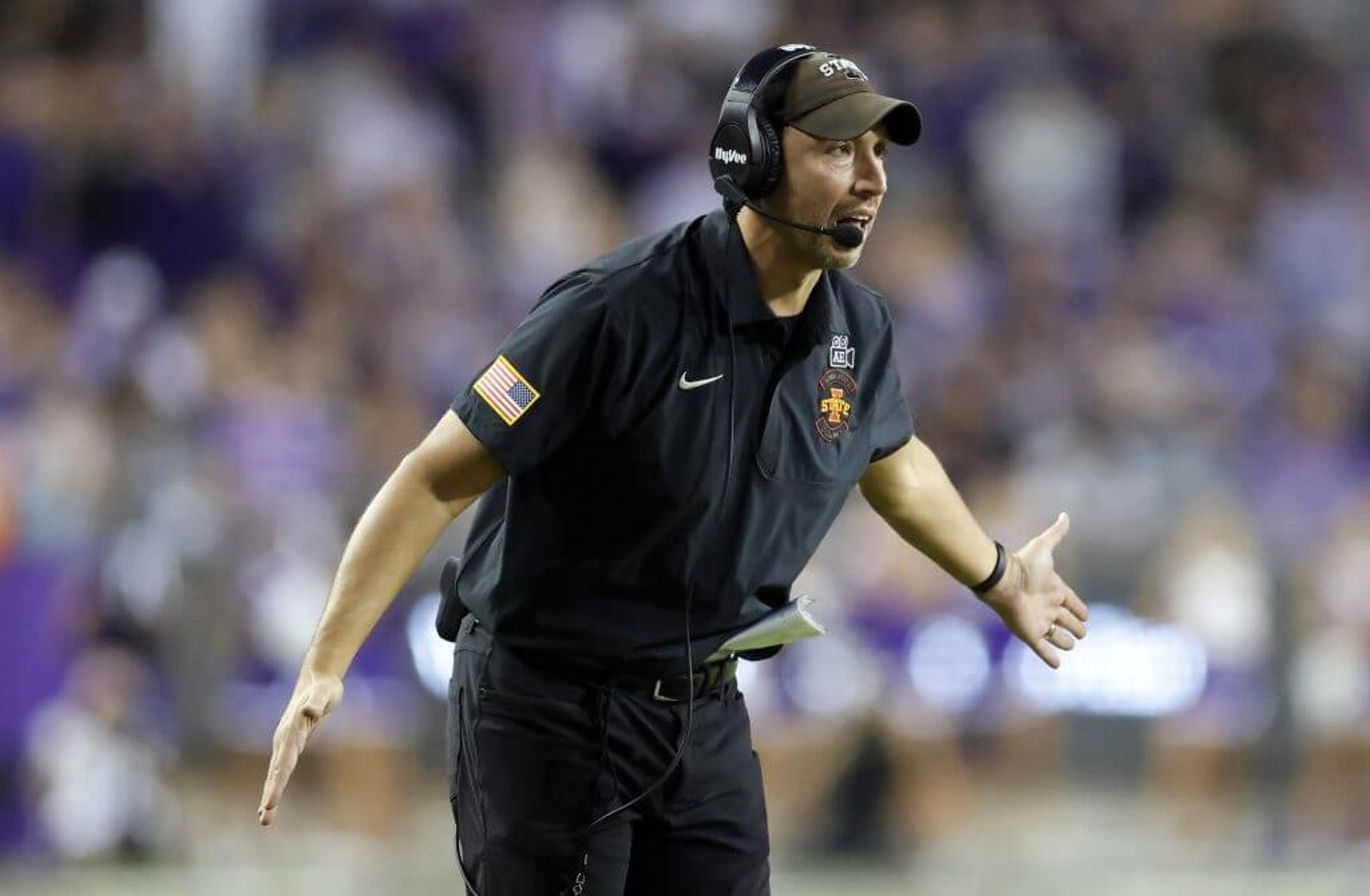 Iowa State football coach Matt Campbell waits to slap hands with players coming off the field