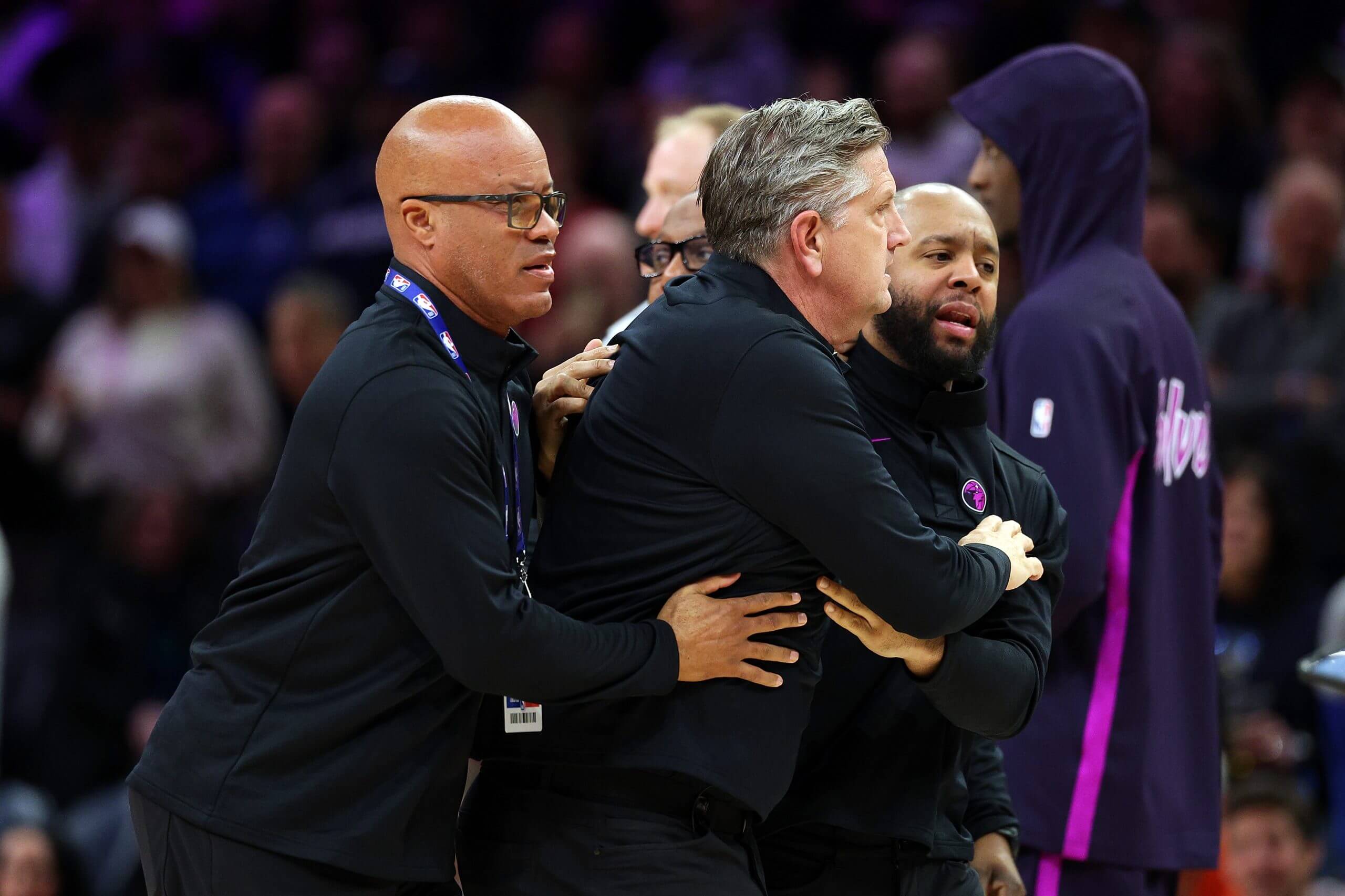 Minnesota Timberwolves coach Chris Finch is held back by his coaching staff after being ejected from a game.