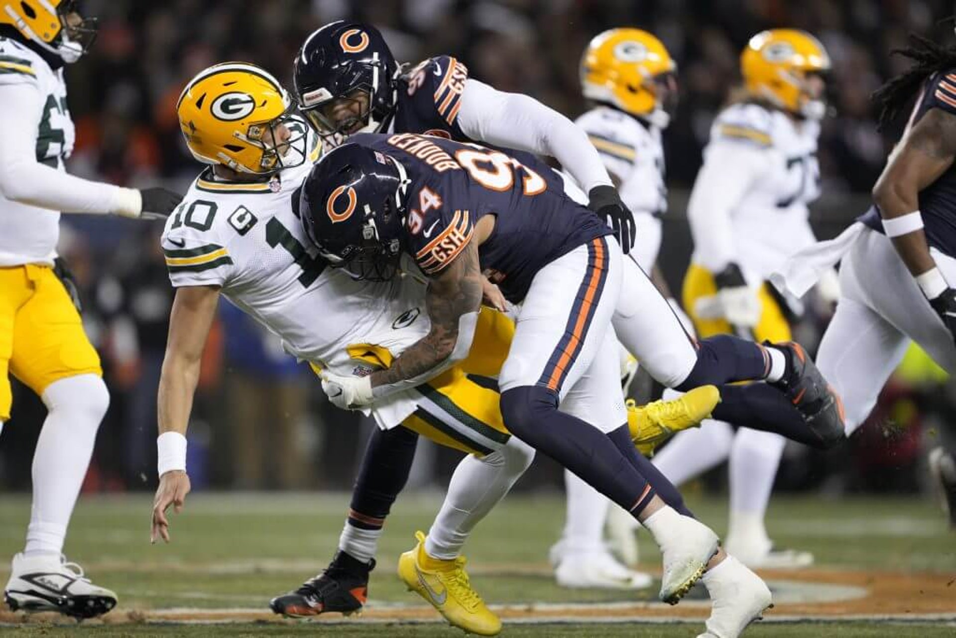 Green Bay quarterback Jordan Love (10) is driven to the ground by Chicago's Austin Booker after a pass attempt.