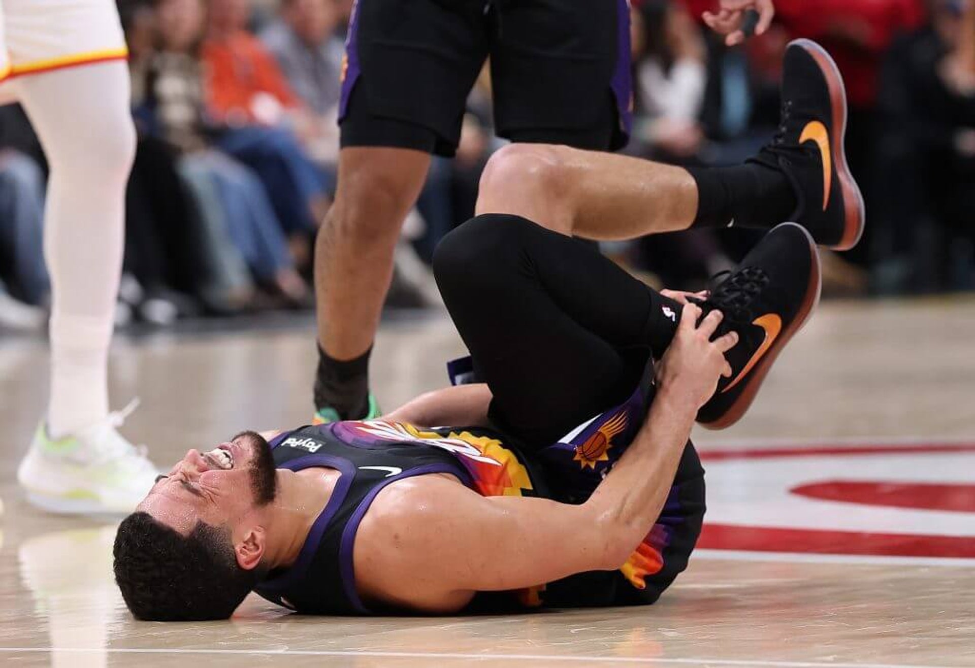 Devin Booker of the Phoenix Suns reacts after injurying his ankle against the Atlanta Hawks during the third quarter at State Farm Arena on Jan. 23, 2026 in Atlanta.